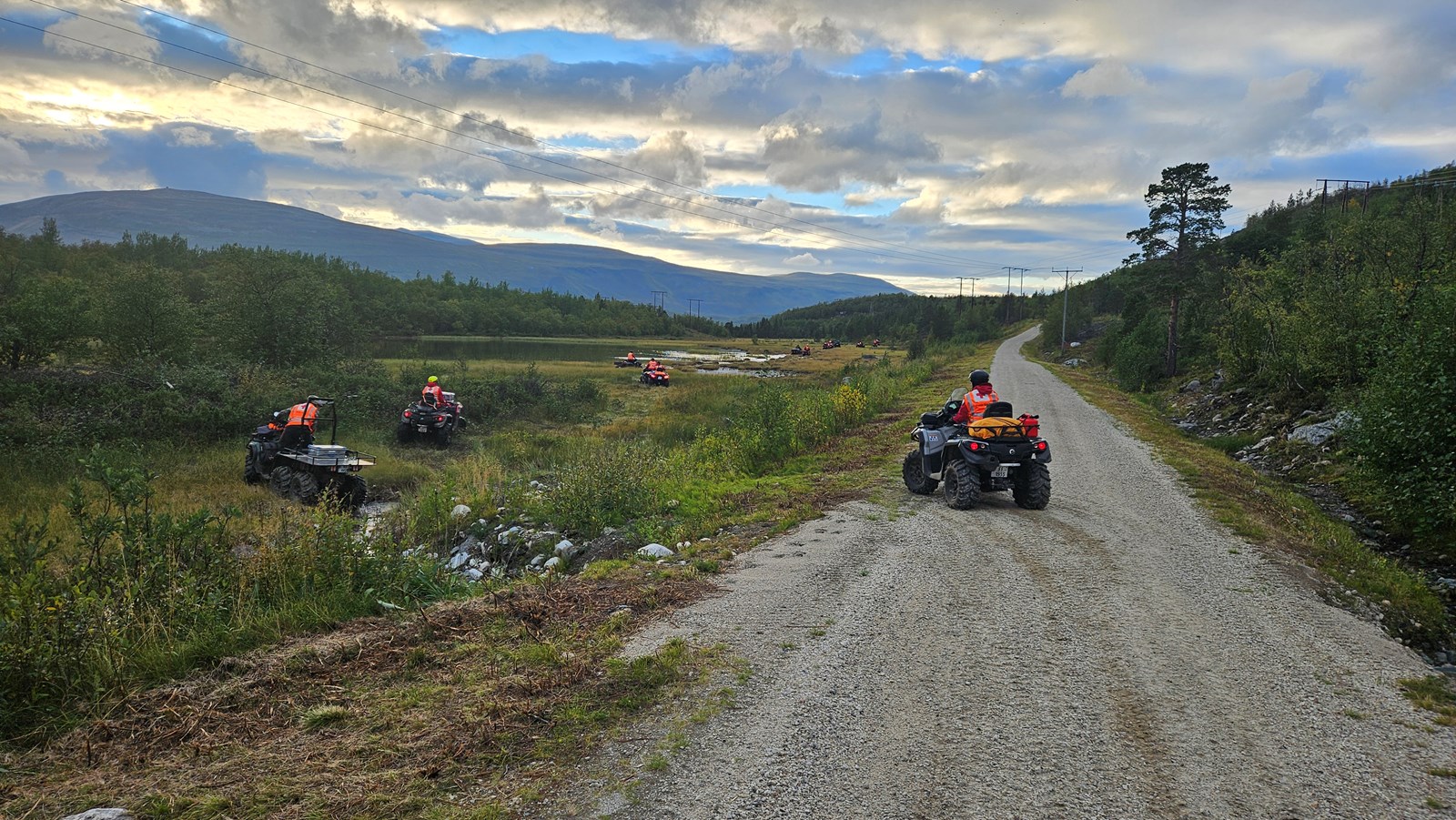 Personer som kjører ATV på vei og myr.