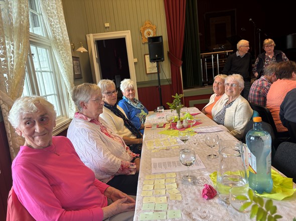 Eldre damer som sitter rundt et bord.