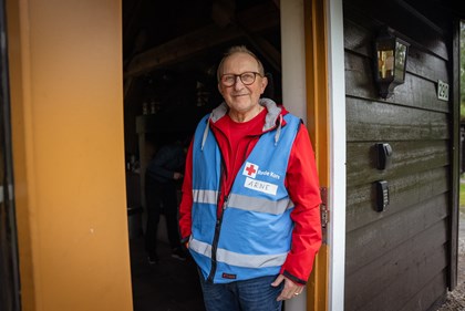 Mann i Røde Kors vest står i døråpning