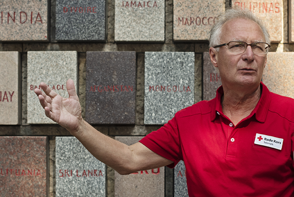 Mann foran minneplaketter med navn på land som har Røde Kors-foreninger