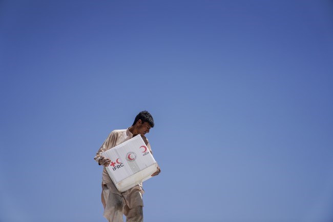 En mann bærer en eske fra internasjonale Røde Kors